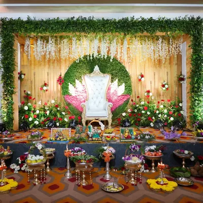 A full view of a Sreemantham stage I decorated. The setup includes a throne-style chair, a lotus-themed backdrop, and a wide array of my decorative platters on gold and silver stands, creating a truly grand look.