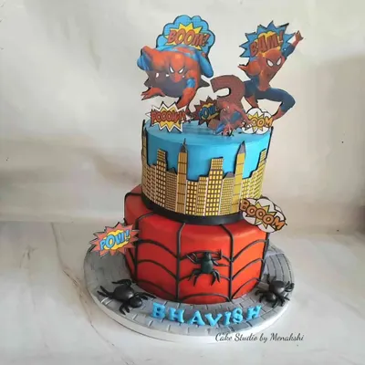 A dynamic two-tier Spiderman cake for a young fan. The bottom tier features the classic web design, while the top shows a city skyline, all brought to life with fun comic book-style toppers.