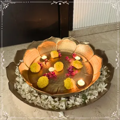 I love creating pieces that bring tranquility and beauty to your home. This large, handcrafted metal urli, styled with floating marigolds and tea lights, creates a serene and welcoming centerpiece, perfect for any festive occasion or to simply elevate your daily living space.