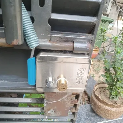 This is a Hawkvision electronic door lock I installed on a metal gate in Noida. It's a robust lock that can be operated with a key or electronically, providing dual security.