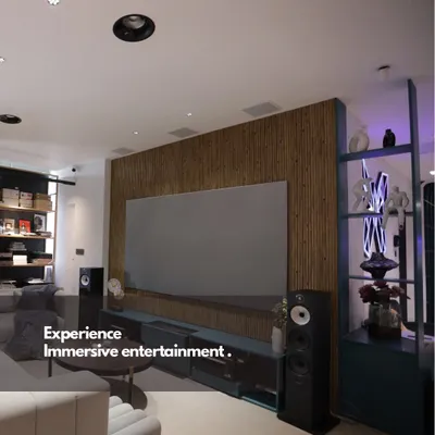 We believe world-class entertainment should blend perfectly with your home's design. This living room setup features a large format screen and high-fidelity tower speakers, creating a powerful media experience that complements the modern interior.