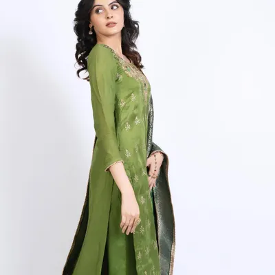 A test shoot featuring a model in an elegant green ethnic suit. The makeup is dewy and minimal, with soft curls in her hair to create a fresh and sophisticated look.