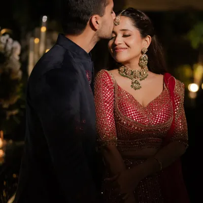 A romantic moment from Janhvi’s cocktail night. Her makeup features a warm, smokey eye and a glowing base that looks incredible in the low light, complementing her red Seema Gujral lehenga.