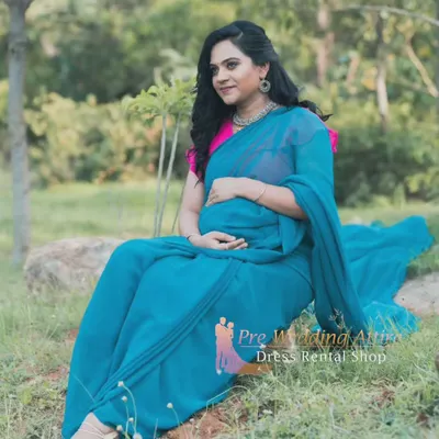 This teal saree-style gown offers a unique and elegant option for your maternity shoot. The flowing fabric drapes like a traditional saree but provides the comfort of a gown, perfect for a relaxed outdoor session.