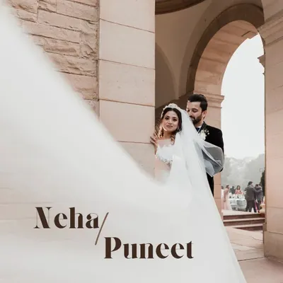 A dramatic portrait of a bride and groom outside a gorgeous Victorian-style church in Delhi. The flowing veil adds a touch of cinematic elegance to their Christian wedding photo.