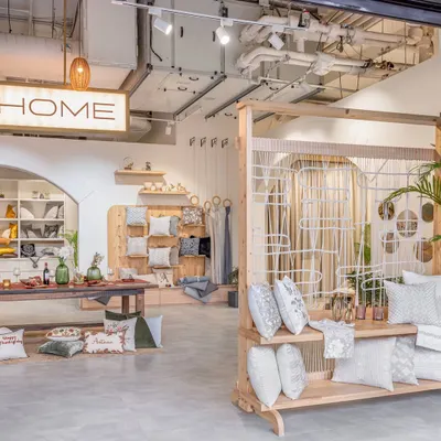 The entrance to the FA Home store reveals an open, airy layout with exposed ceiling services and warm lighting. We designed the space to be inviting, with curated product displays that draw customers in to explore the artisanal textiles.
