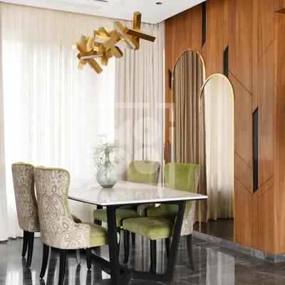 Welcome to our recently handed-over Dadar project. This dining area features plush green chairs, a statement chandelier, and a rich wood-paneled wall, creating a space that is perfect for elegant entertaining.
