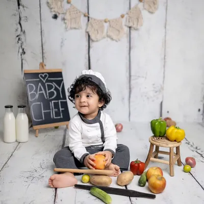 Our little chef is ready to cook up a storm! This sitter session is styled with a chef's uniform, a chalkboard, and plenty of colorful fruits and vegetables.