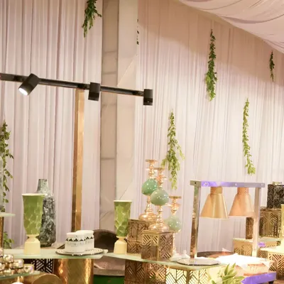 A stylish decor arrangement featuring modern metallic vases, candle holders, and track lighting. We use these elements to create a sophisticated and contemporary atmosphere.