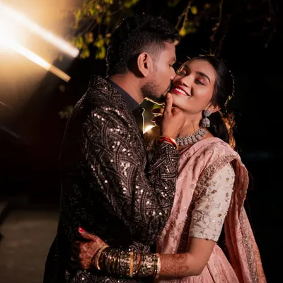 A stolen, playful moment during their Sangeet night. The dramatic lighting and his affectionate gesture make this a memorable and heartwarming candid shot.