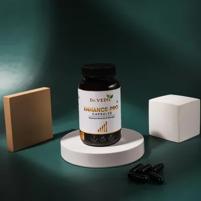 A clean and minimalist shot of Dr. Vedic Enhance-Pro capsules. The product is placed on a white podium against a dark green background, with dramatic lighting to create a premium feel.