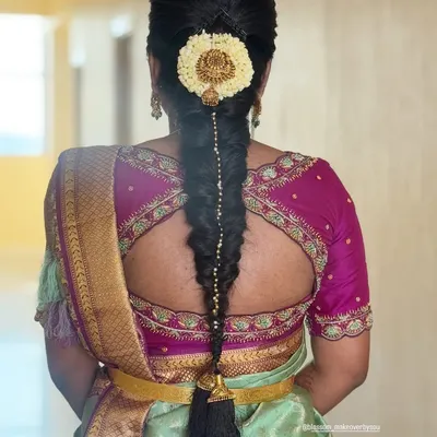 A traditional South Indian bridal braid is a work of art. This classic fishtail braid, adorned with jasmine flowers and a statement gold jada, is a timeless choice for a muhurtham ceremony.