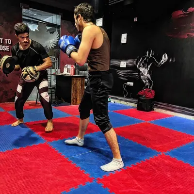 During one-on-one pad work, I correct your form in real-time. This drill is for developing speed and precision in your striking, ensuring every punch lands with impact.