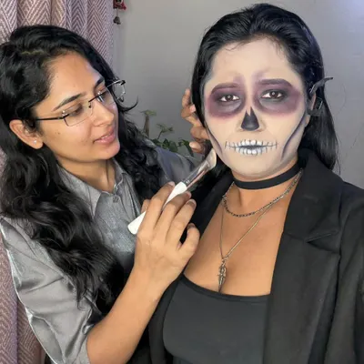 Here I am in action, applying the final touches to a skeleton makeup look. I work closely with my clients to make sure they are comfortable and happy throughout the entire creative process.