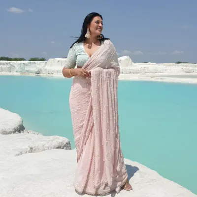A moment of serenity at the Kishangarh marble dumping yard. This beautiful pastel pink saree with delicate pearl work creates a stunning contrast against the surreal blue water, showing how a saree can be perfect for a dramatic photoshoot.