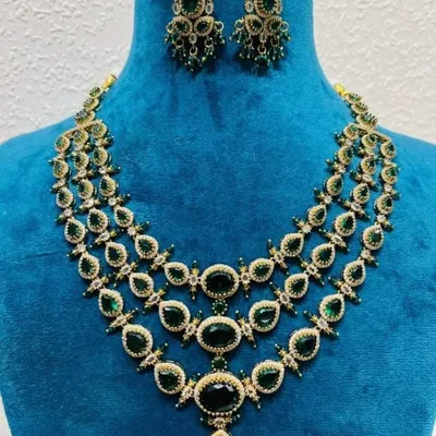 A Victorian-style three-layer necklace with matching earrings. The set features large emerald-green stones, perfect for adding a pop of color to your reception outfit.