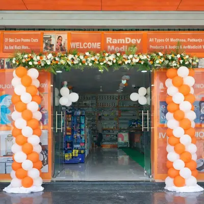 This setup for a pharmacy grand opening shows how I combine different elements for a cohesive look. The vibrant orange and white spiral balloon pillars frame the entrance, while a fresh flower toran adds a touch of traditional elegance, making the storefront inviting and celebratory.