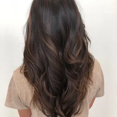 This brown balayage is our signature look for dark hair. The caramel and chocolate tones are hand-painted to create natural-looking dimension and movement, perfect for a low-maintenance but high-impact style.