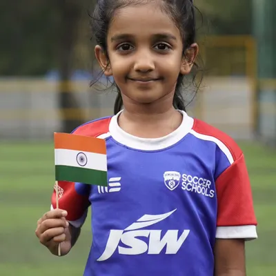A young girl from our soccer school holds the Indian flag with pride. We are dedicated to nurturing the next generation of female athletes for our country.