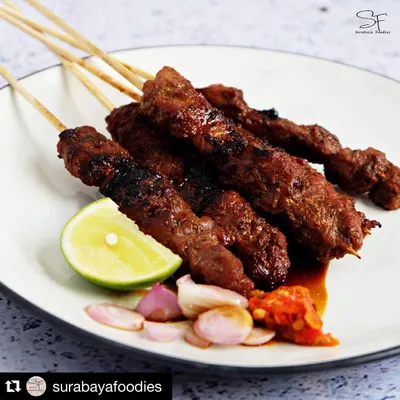 A close-up of our signature Sate Babi, served with fresh lime and spicy sambal. This professional shot from @surabayafoodies really captures how delicious it is!