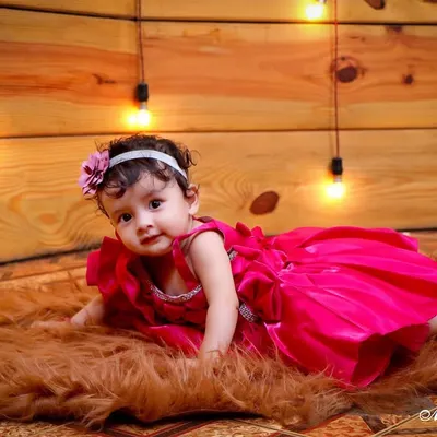 This is from a milestone session, perfect for when babies can sit up and show off their personality. I used a warm, wood-paneled backdrop with string lights and a soft fur rug to create a cozy setting for this baby girl's portrait.