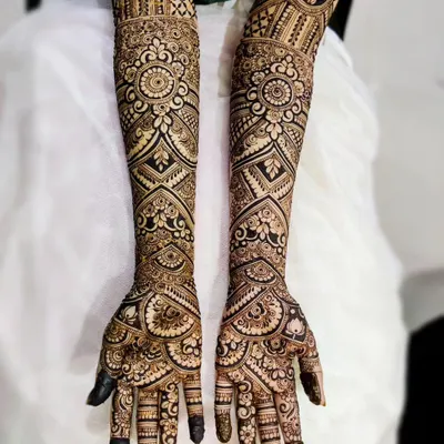 A mega bridal henna design for Saleha, covering the arms almost to the elbow. This style is incredibly detailed, with repeating mandalas, geometric grids, and floral patterns for a truly grand look.