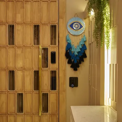 The entrance to your home should make a statement. This custom wooden door with intricate paneling, paired with an evil eye charm, creates a warm and personal welcome.