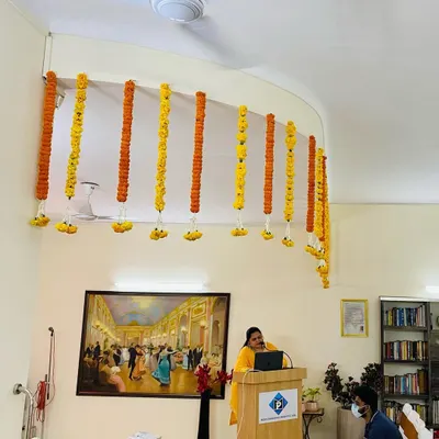 For corporate events like seminars or conferences, I create simple yet elegant ceiling decorations. These vertical flower strings of fresh marigolds hang above the main stage or podium area, adding a special touch without being distracting.