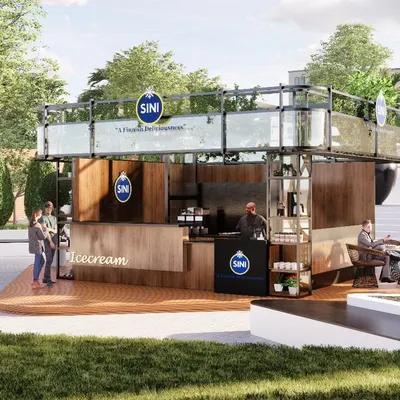 This render shows a modern food and beverage kiosk designed for an urban plaza. The structure features a rooftop green space and is made from brushed metal, glass, and oak paneling. Minimal seating at the kiosk encourages people to explore the surrounding plaza.