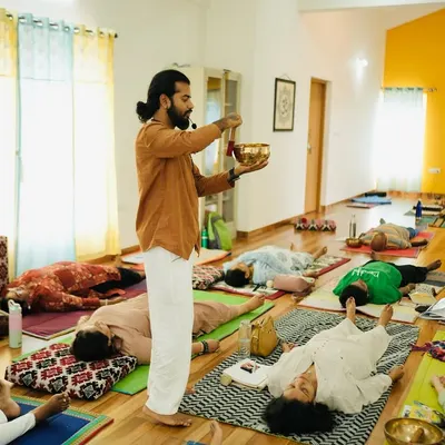 During a sound healing teacher training course, I guide participants into a state of deep rest, known as Yoga Nidra. Here, I am using a Tibetan singing bowl to create gentle vibrations that calm the nervous system.