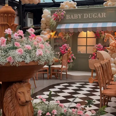 A glimpse into the Parisian-themed "Bonjour Bébé" baby shower, where a custom market stall and lush florals created a charming street-side cafe vibe.