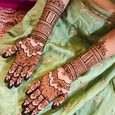This is a classic full bridal mehendi with extremely fine and intricate details. The patterns include delicate paisleys, florals, and geometric fills, creating a rich and luxurious look.
