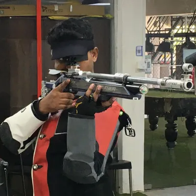 A shooter demonstrates intense focus during a 10m Air Rifle practice session. Notice the precise alignment and steady hold, techniques we drill down to the finest detail.