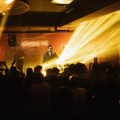 A wide shot of Mika Singh performing at Studio XO, capturing the impressive stage lighting and the large, engaged audience. This shows our ability to capture the entire event atmosphere.