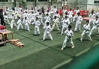 A snapshot of our large group training session on an outdoor turf. Students are practicing their basic stances and blocks in unison, building a strong foundation in Taekwondo discipline and form.