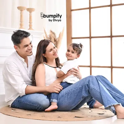 A relaxed and happy family portrait in our bright, airy studio. The simple, modern setup with a fireplace and pampas grass allows the family's connection to be the main focus.