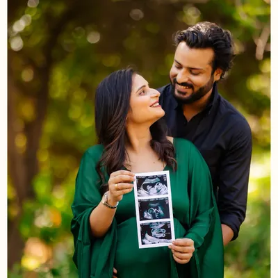 The first family photo. An expecting couple in a beautiful park setting, proudly holding up their baby's sonogram pictures for the world to see.