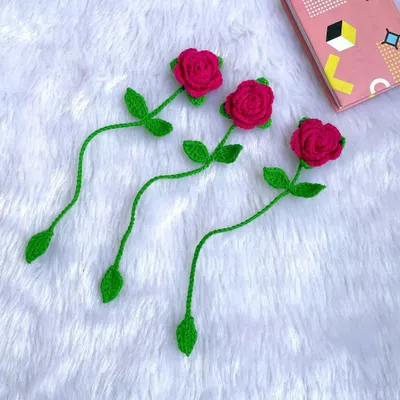 A set of three delicate red rose bookmarks. The long green stem tucks into the book, leaving the beautiful rose peeking out from the top.