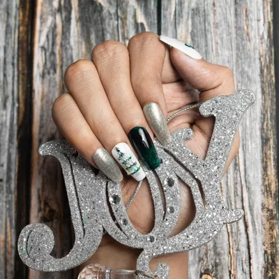 Get into the festive spirit with this Christmas nail set. It features a mix of green chrome, silver glitter, and a hand-painted Christmas tree for a joyful holiday look.