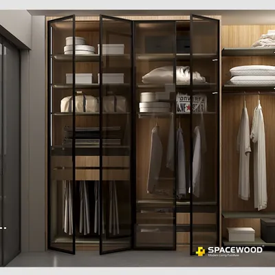 This walk-in wardrobe combines warm wood interiors with sleek, black-framed tinted glass doors. The integrated LED lighting illuminates your collection, making it easy to find exactly what you need while creating a sophisticated, boutique-like feel in your own home.