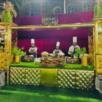 My grand, golden chaat counter, where chefs in traditional attire prepare a variety of Indian street food favorites.