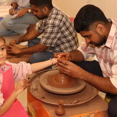 A young girl gets her first lesson in pottery, guided by one of our instructors. This tactile activity is a wonderful way to explore physics and creativity at the same time.