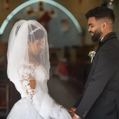 A quiet moment for the couple at the church entrance before the ceremony begins. The veil adds a touch of softness and intimacy to this beautiful Catholic wedding photograph.