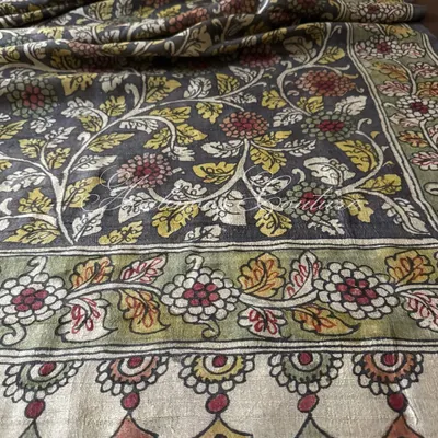 A detailed view of the border of our charcoal grey silk dupatta. It features a traditional floral border in earthy tones, complementing the intricate vine pattern of the main body.