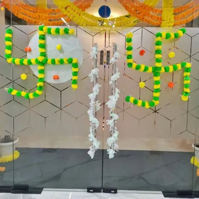A traditional Swastika symbol made from marigold flowers on the main glass door, creating an auspicious and welcoming entrance for Diwali.