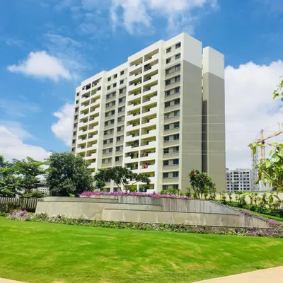 A wide view of a landscaped area for a multi-story apartment building, featuring a lush green lawn and manicured garden beds. This demonstrates our work on large residential projects.