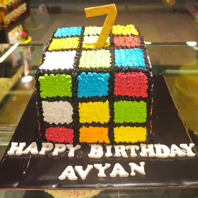 A puzzle you can eat. This Rubik's Cube cake is meticulously decorated with colorful frosting squares to look just like the classic 80s toy, perfect for a themed party.
