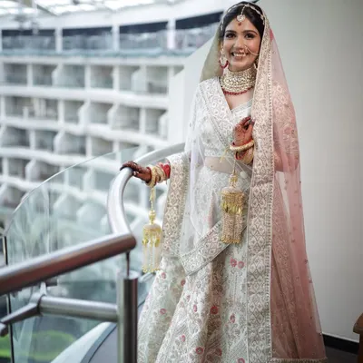 An absolutely angelic bride. Her smile and the stunning ivory lehenga are the stars, supported by a soft, glowing makeup look.
