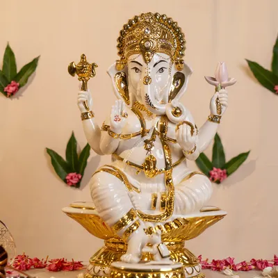 This magnificent porcelain Ganesha, finished with brilliant gold detailing, is designed to be a beacon of light and devotion in your home. Seated on a lotus, he brings blessings for new beginnings and prosperity.