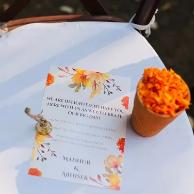 It's the small touches that make your guests feel truly part of your story. For this ceremony, each guest received a cone of marigold petals, a small bell, and a note inviting them to ring the bell and shower the couple with blessings during the pheras.